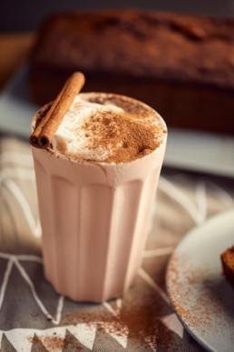 Cappuccino with cocoa and cinnamon stick.