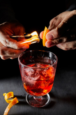 Flaming orange peel for Negroni cocktail