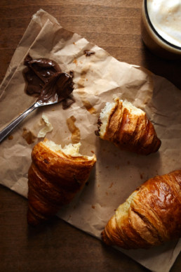 Fresh croissant with hazelnut spread and coffee for breakfast