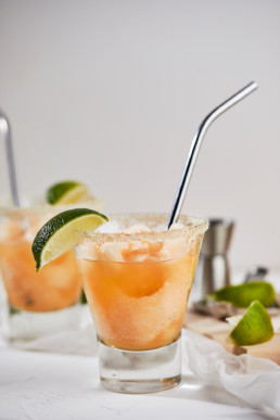 Glass full with frozen non-alcoholic margaritas garnished with lime wedge