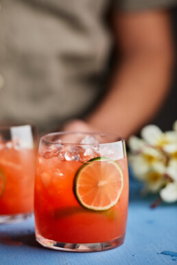 Pineapple hibiscus mocktail garnished with lime slices