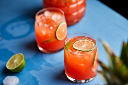 Pineapple hibiscus mocktail garnished with lime slices