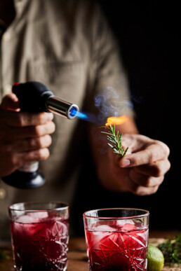 Burning the sprigs of rosemary as a garnish for mocktail