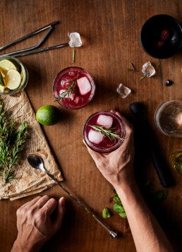 Man holding glass with blackberry lime mocktail