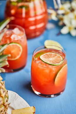 Pineapple hibiscus mocktail garnished with lime slices