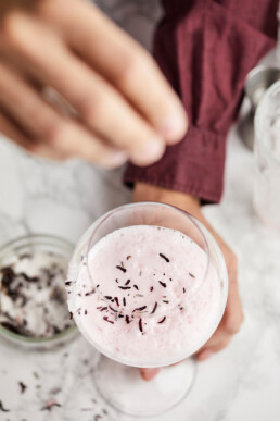 Sprinkling a mixture of hibiscus tea, lavender and sugar onto the mocktail