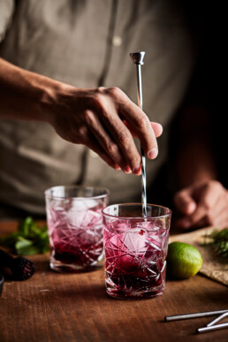 Stirring all ingredients for mocktail in a glass vith a bar spoon